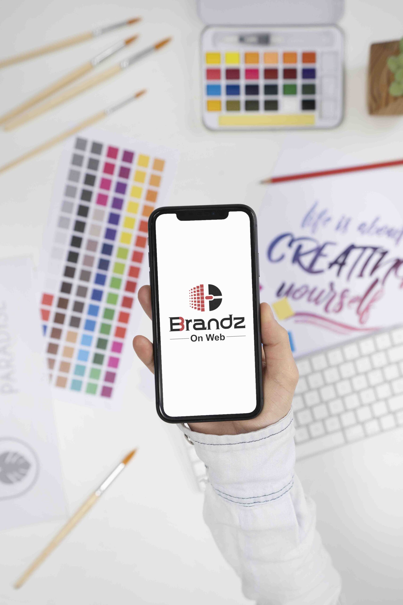 logo-designer-holding-smartphone-with-cool-logo-it-scaled